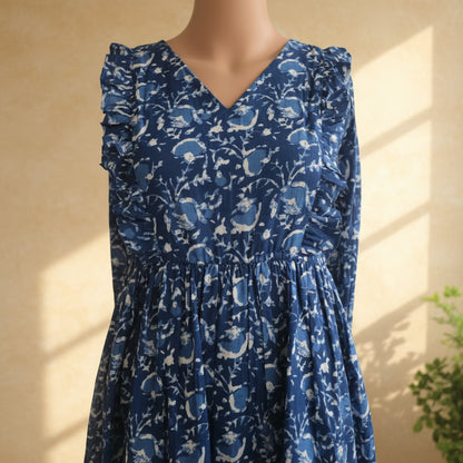 Close-up of indigo floral print cotton dress showing white floral motifs, V-neckline and ruffle trim